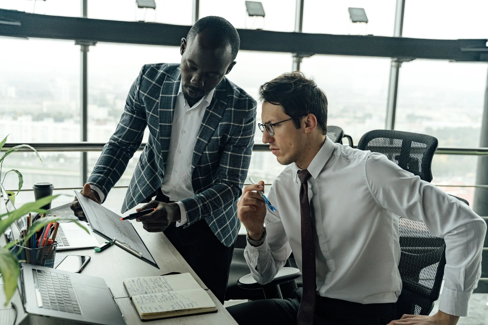 Two business professionals reviewing work together in an office